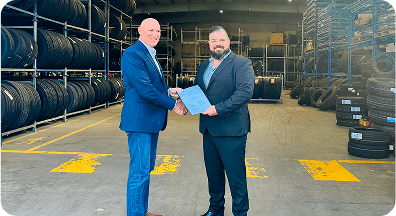 Business handshake in warehouse marking tyre supply partnership agreement and industrial collaboration